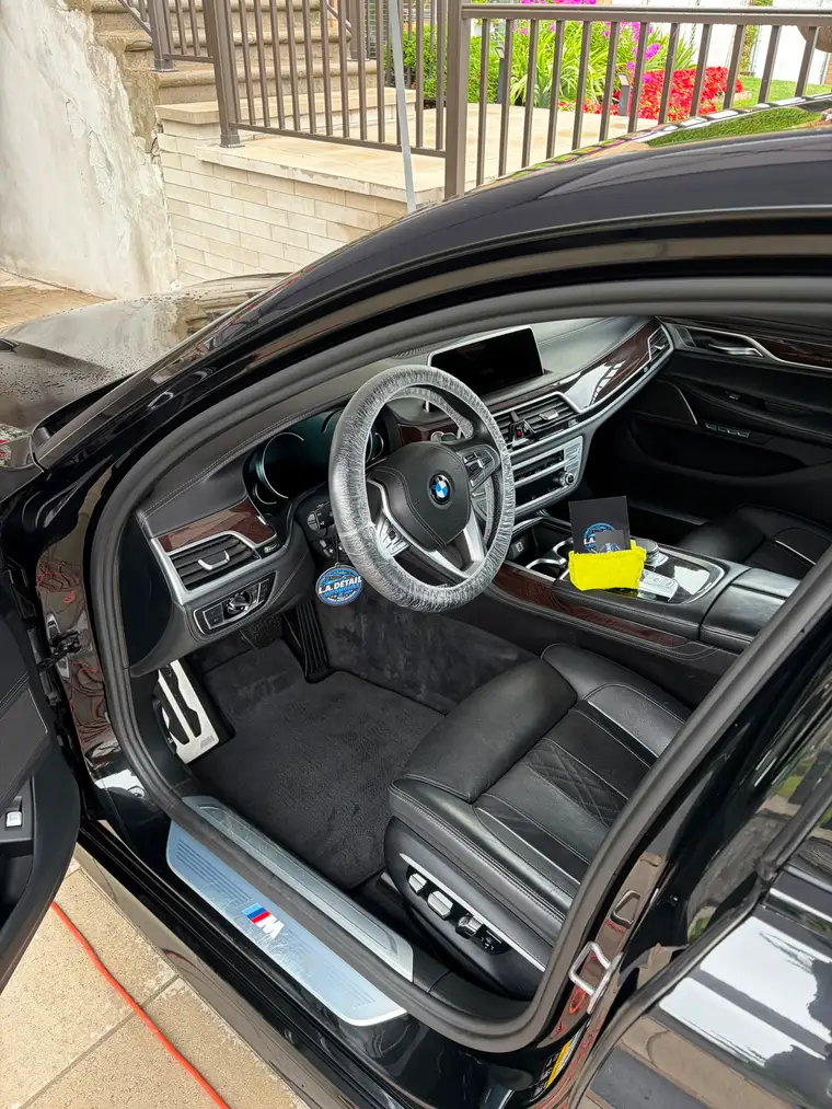 BMW 7 Series interior after a full detail, wood trim and black leather cleaned and protected