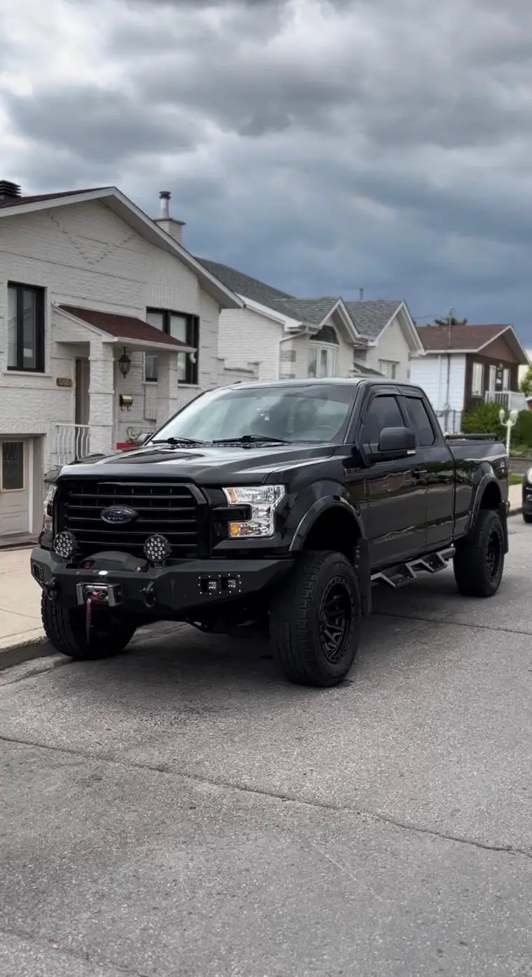 Lifted black Ford F-150 gleaming after a full exterior detail