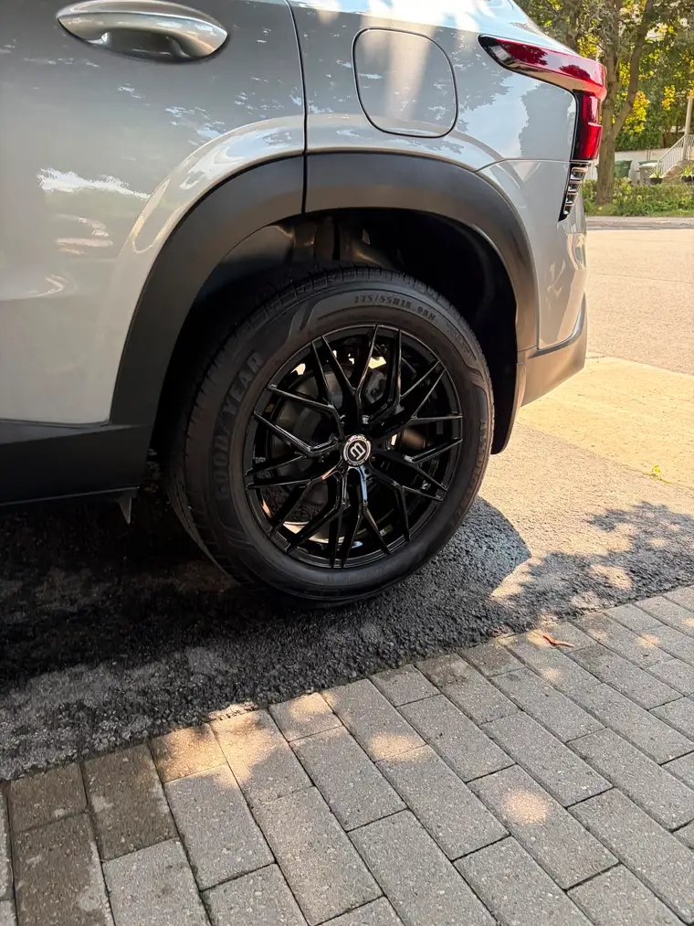 Gloss black aftermarket wheel and freshly dressed tire on a grey SUV in Montreal