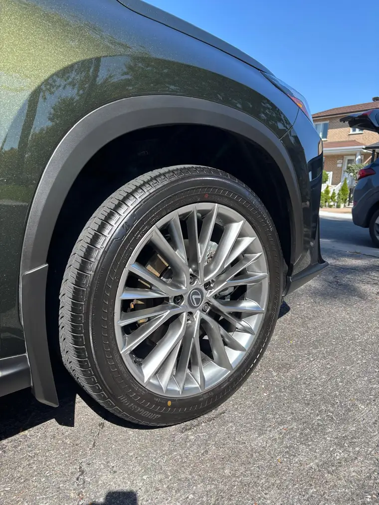 Polished Lexus RX wheel and glossy dark green paint after mobile detailing in Montreal