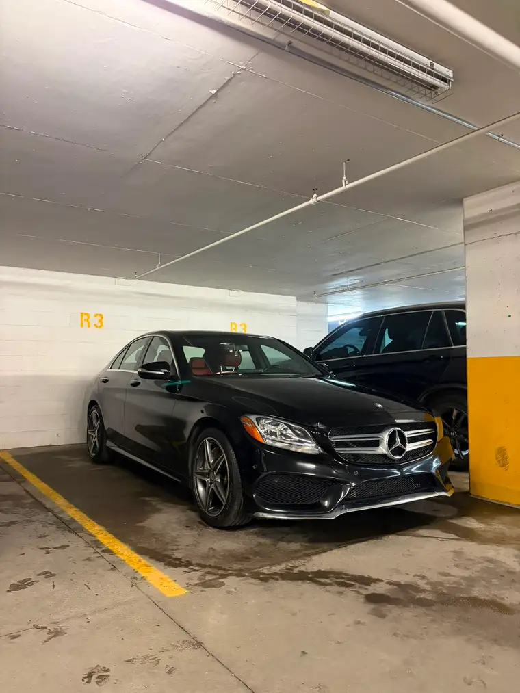 Black Mercedes-Benz C-Class detailed on site in an underground parking garage in Montreal