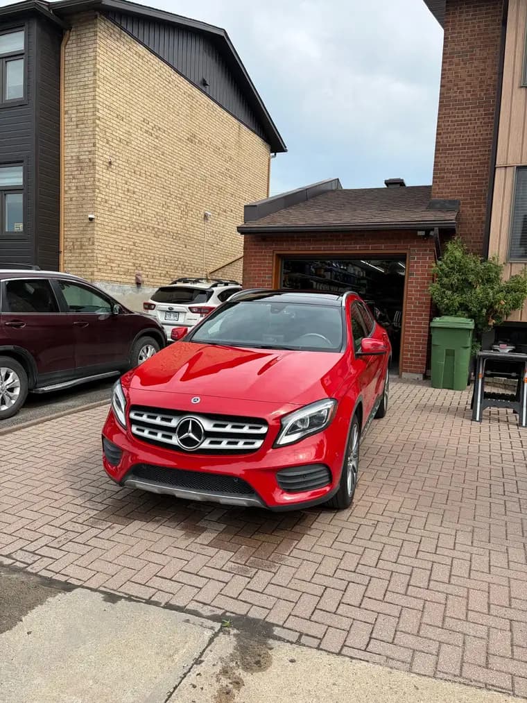 Red Mercedes-Benz GLA freshly washed on a paver driveway