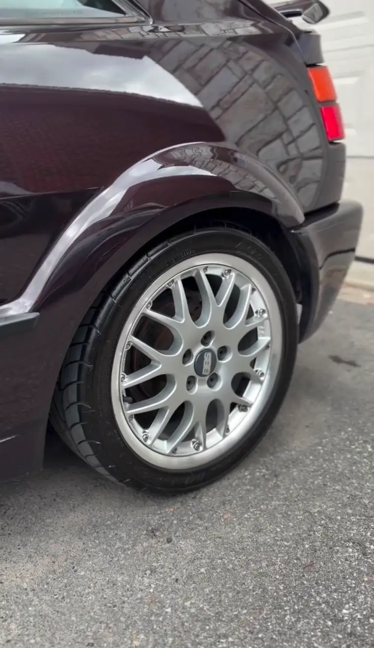 Classic mesh wheel polished clean against burgundy paint