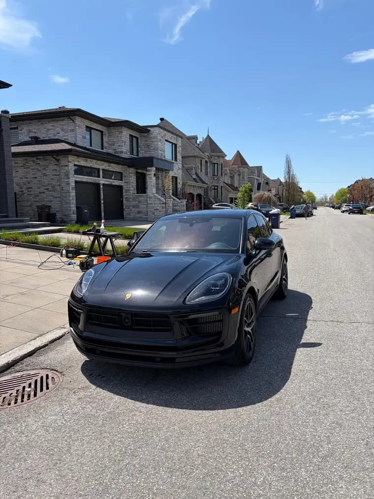Black Porsche Macan detailed at the customer's home, mobile service setup visible