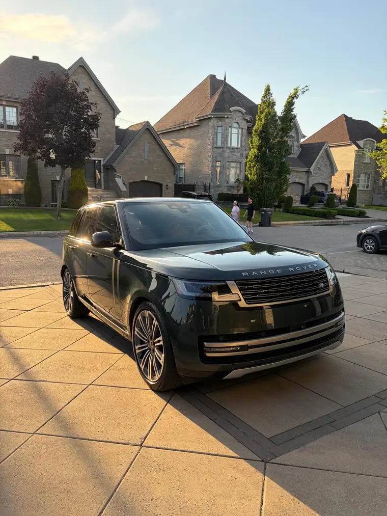 Dark green Range Rover freshly detailed at golden hour in a Montreal driveway