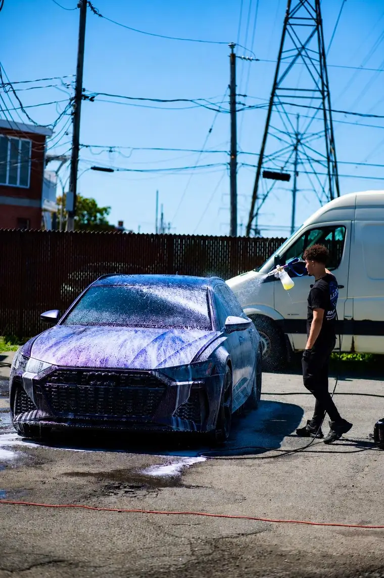 Wide view of an Audi RS6 under snow foam during a mobile detailing session