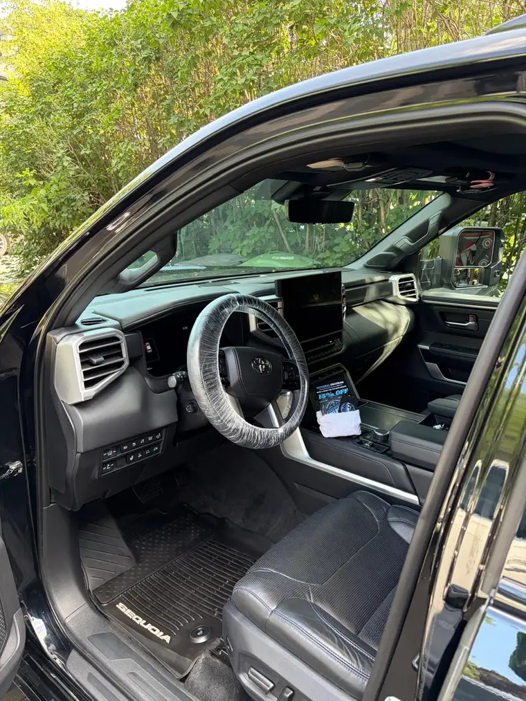 Toyota Sequoia interior deep-cleaned, wheel wrapped, referral card on display