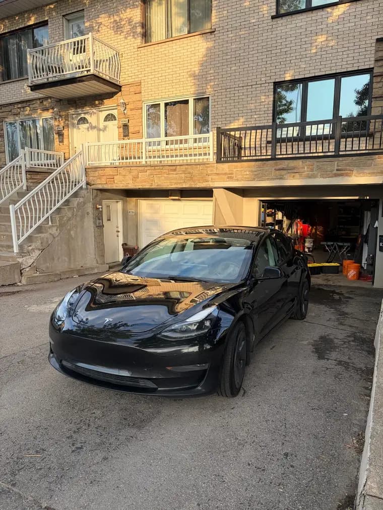 Black Tesla Model 3 with glass-like paint after exterior detailing